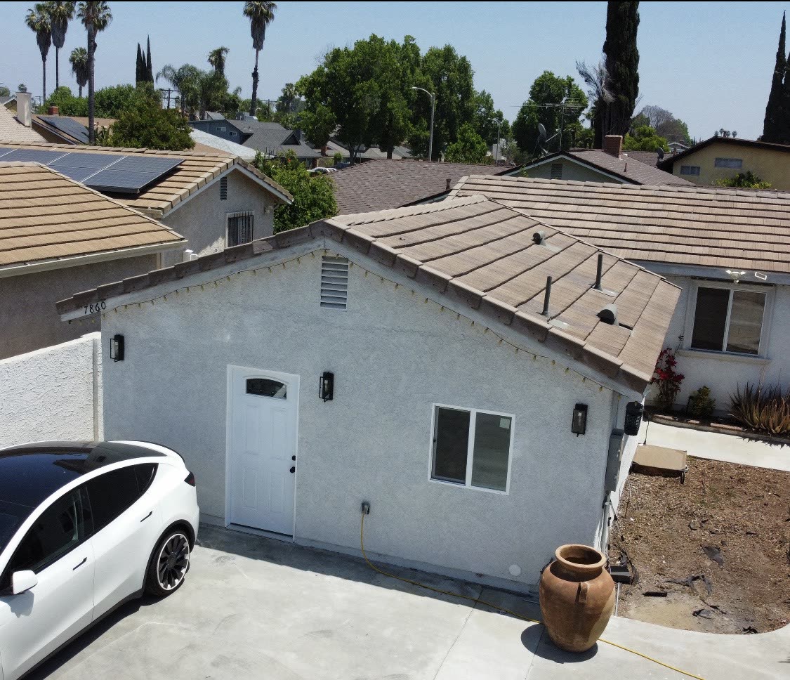 Aerial view of a finished ADU with tile roof next to the main house