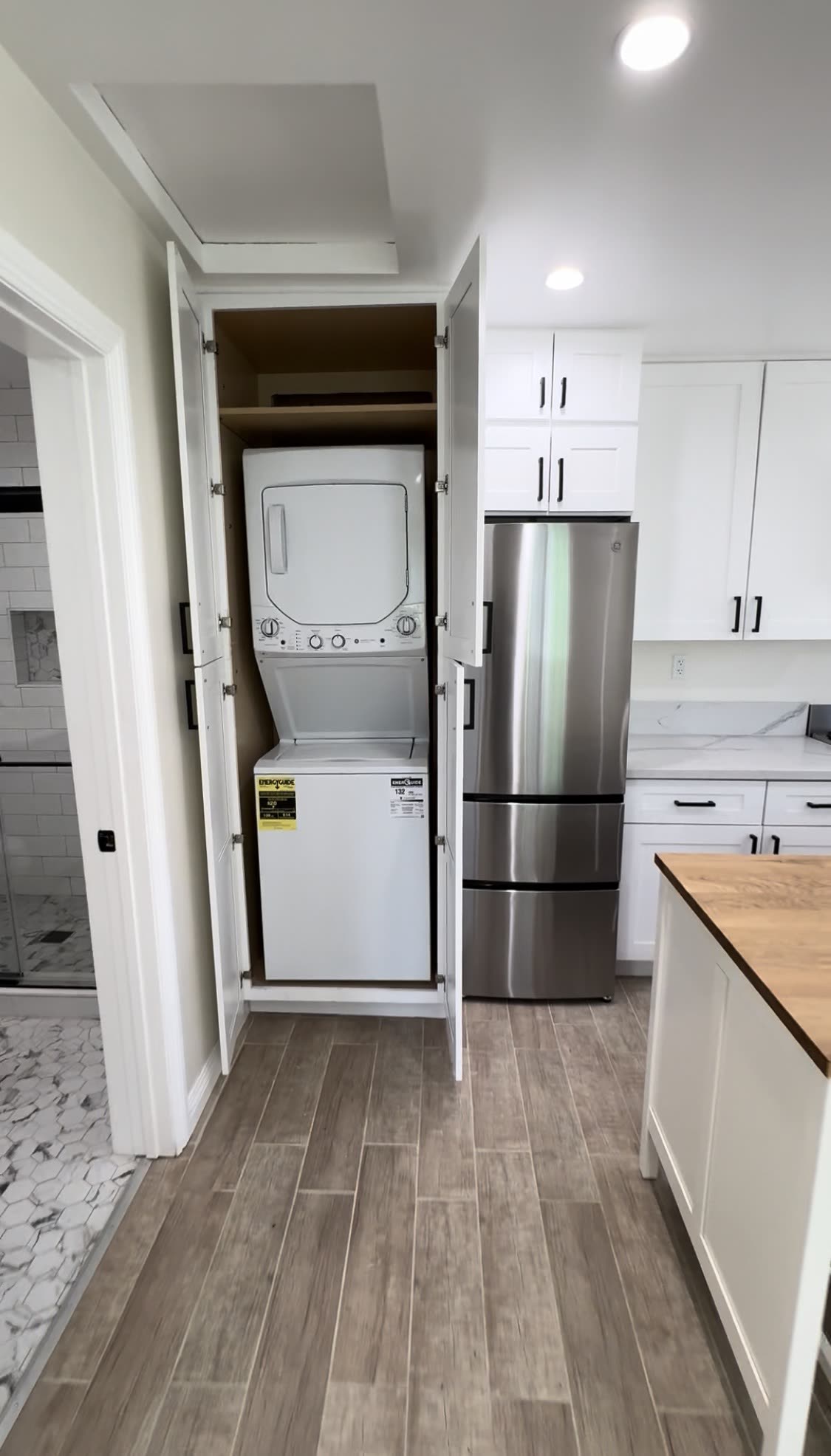 Kitchen with built-in stacked laundry nook and butcher-block island