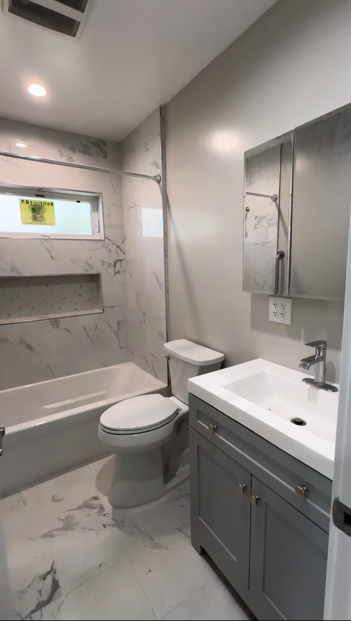 Bathroom remodel with white bathtub and marble wall tile